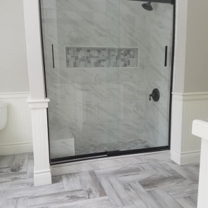 A bright and crisp look was the aim for this bathroom remodel in Falmouth, Maine. The Aged bronze trim kit creates a nice contrast to the lighter shower tile. 
